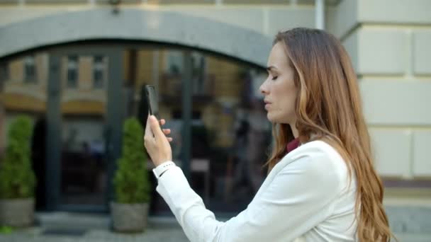 Serieuze zakenvrouw hebben vdeio conferentie online op smartphone buiten — Stockvideo