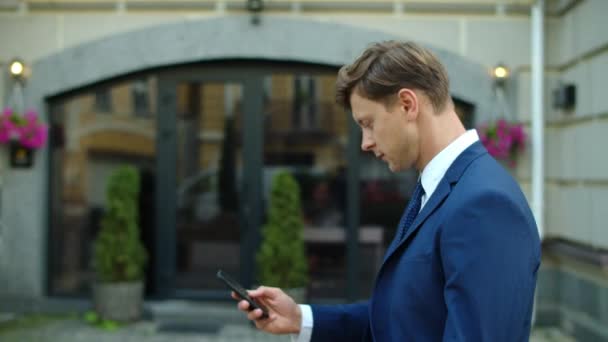 Homem de negócios bem sucedido usando telefone celular ao ar livre. Empresário surpreso — Vídeo de Stock