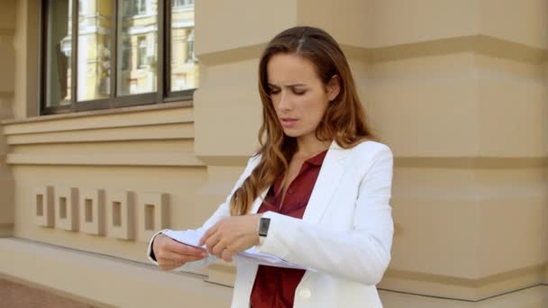 Ernsthafte Geschäftsfrau beim Lesen von Dokumenten im Freien. Fokussierter Profi — Stockvideo
