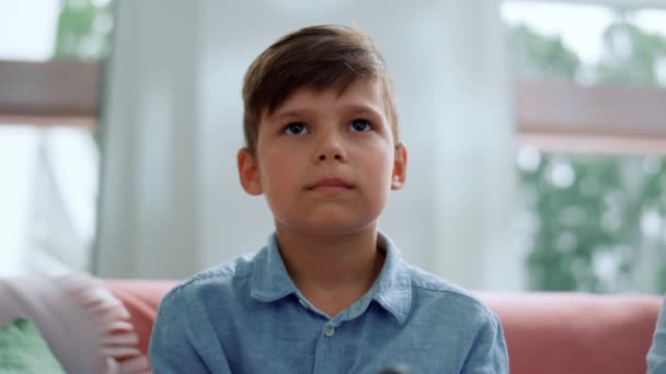 Niño jugando juego de ordenador con joystick en la sala de estar. Gamer usando gamepad — Vídeo de stock