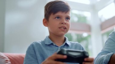 Çocuk bilgisayar oyunu için oyun sahası kullanıyor. Erkek oyuncu joystick 'te düğmelere basıyor