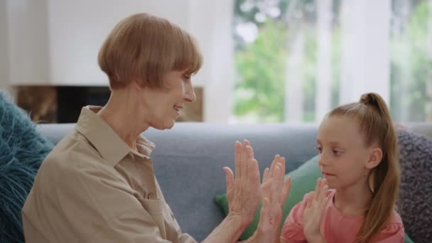 Gelukkig oma en kleindochter spelen patty cake thuis — Stockvideo