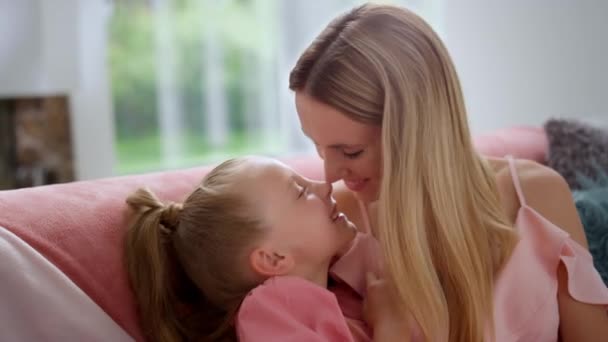 Jolie fille et mère heureuse touchant le nez. Femme souriante jouant avec sa fille — Video