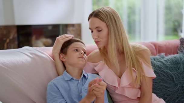 Rapaz a conversar com a mãe em casa. Mãe e filho sentados no sofá — Vídeo de Stock