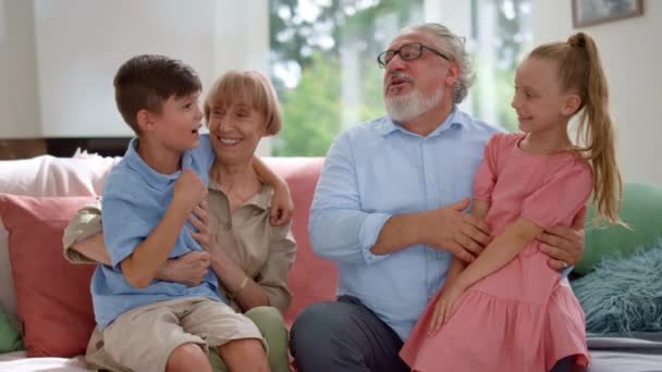 Feliz abuelo y abuela hablando con nietos en casa — Vídeos de Stock