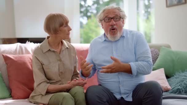 Kobieta i mężczyzna rozmawiają w pokoju. Dziadkowie witają wnuki w domu — Wideo stockowe