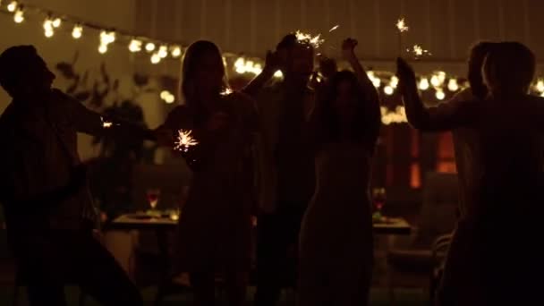 朋友们在后院跳舞快乐的男孩和女孩手握火花 — 图库视频影像