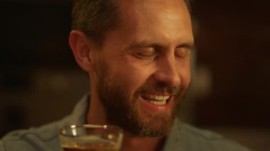 Yemek sırasında tost yapan yakışıklı bir adam. Gülümseyen adam ailesiyle konuşuyor.