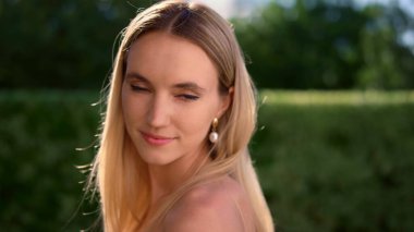 Omzuna bakan şefkatli bir kadın. Dışarıdaki kameraya bakan gülümseyen bayan.