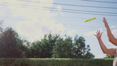 Arka bahçeye uçan disk atan bir kadın. Genç adam uçan diski havada yakalıyor.