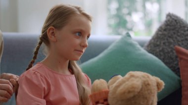 Odadaki kanepede oturan kız. Büyükannem torunumun saçlarıyla ilgileniyor.