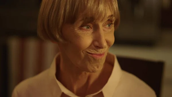 Usmívající se starší žena při večeři pronáší přípitek. Starší dáma mluví s rodinou — Stock fotografie
