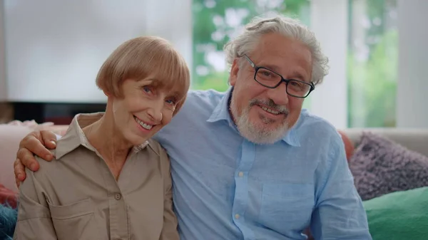 Smilende eldre mann og kvinne som ser inn i kamera. Ektemannsklem kone – stockfoto