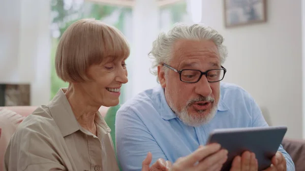 Isoäiti ja isoisä puhuvat videopuhelu tablet-laitteella lastenlasten kanssa — kuvapankkivalokuva