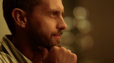 Çenesinde el ele tutuşan düşünceli bir adam. Şaşırmış yüz ifadesi olan sakallı adam.