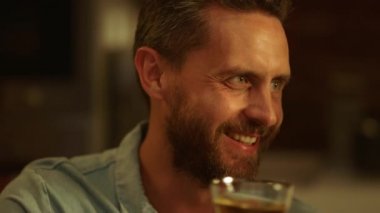 Gülümseyen adam elinde bardakla tost yapıyor. Ailesiyle kadeh tokuşturan adam.