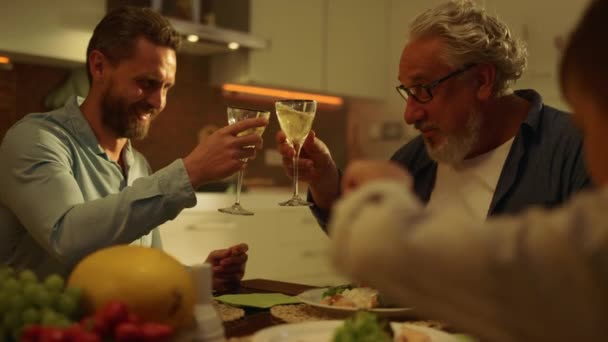 Oudere grootvader, volwassen zoon en kleinzoon dineren samen in de keuken — Stockvideo