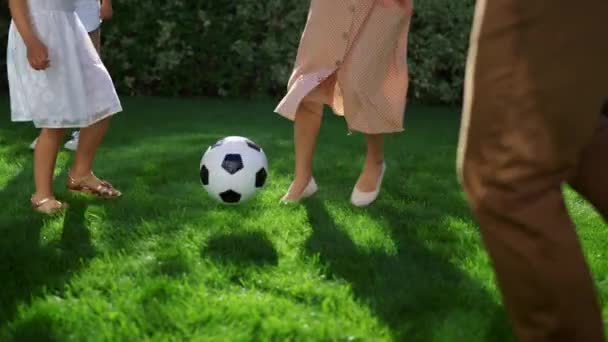 Rodiče a děti hrají fotbal. Otec vyhazuje fotbalový míč do vzduchu — Stock video