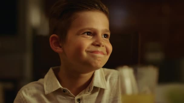 Un garçon qui porte un toast pendant le dîner. Enfant joyeux cliquetis lunettes avec la famille — Video