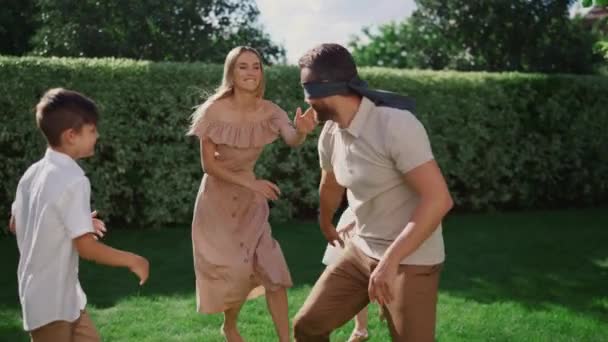 Man in blindfold playing outdoor game with family. Family spending time together — Stock Video