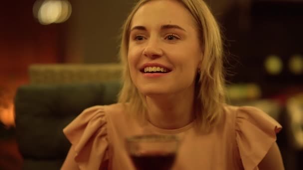 O femeie care stă la masă. Laughing girl toasting cu pahar de vin — Videoclip de stoc