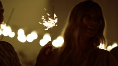 Yeni yılı dışarıda kutlayan mutlu arkadaşlar. Gençler arka bahçede dans ediyor.