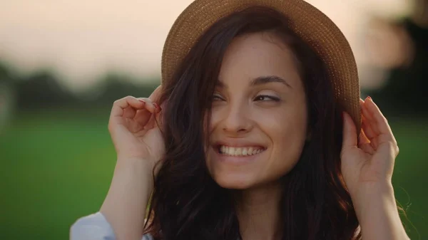 Donna sorridente che indossa un cappello di paglia all'aperto. Ritratto di donna gioiosa nel parco — Foto Stock