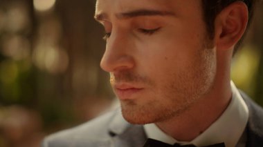 Damat bahçede kemerin altında gergin hissediyor. Adam parkta daha iyi papyon takıyor.