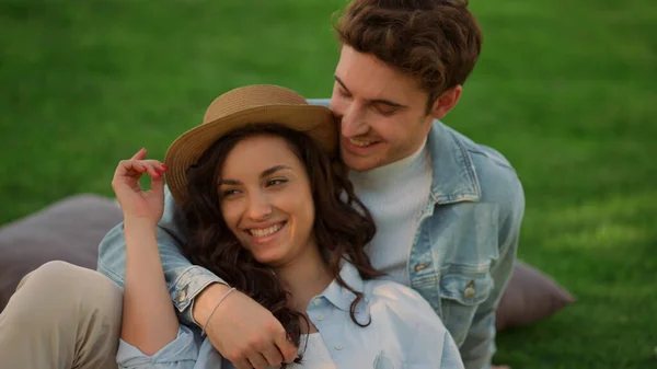 Ragazza positiva e ragazzo che stanno parlando nel parco. Coppia sdraiata a terra — Foto Stock