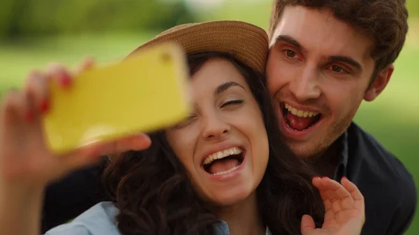 公園のカメラでハイと言う幸せな女の子と男。男かむ女性耳上のピクニック — ストック写真