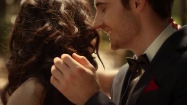 Bahçede gülen neşeli bir çift. Dışarıda kadın saçı koklayan çekici bir adam.