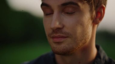 Dışarıda poz veren çekici bir adam. Çayırda tereddüt eden yakışıklı erkek.