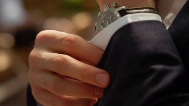 Hombre rico abotonando la manga de la camisa bajo el arco. Manos de hombre con reloj de pulsera — Vídeos de Stock