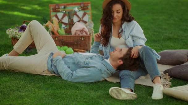 迷人的男人躺在外面女人的腿上。夫妻在野餐上花时间 — 图库视频影像