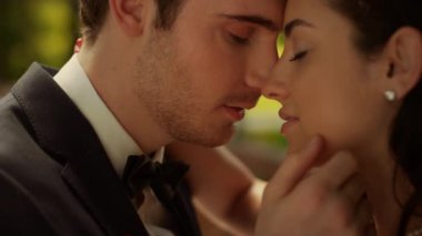 Ateşli gelin ve damat bahçede tutkuyla sarılıyorlar. Erkek ve kadın burunlara dokunuyor