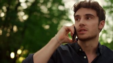 Dışarıda telefonla konuşan ciddi bir adamın portresi..