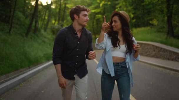 Pareja de amor caminando por la carretera. Chica alegre y chico saltando en la carretera al aire libre. — Vídeos de Stock