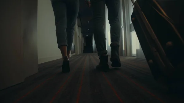 Kilka nóg spacerujących korytarzem hotelowym. Nieznana para podróżująca razem. — Zdjęcie stockowe
