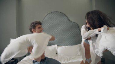 Yatakta kucaklaşan sevimli bir çift. Yastık savaşından sonra düşen muhteşem çift..