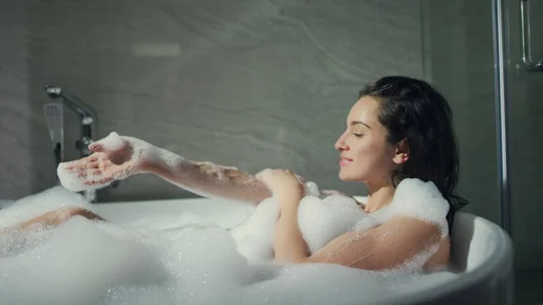 Menina feliz se divertindo na banheira dentro de casa. Mulher linda desfrutando de banho no hotel — Fotografia de Stock