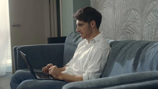 Alegre empresario leyendo el mensaje portátil en el interior. Hombre feliz escribiendo en el ordenador portátil — Foto de Stock