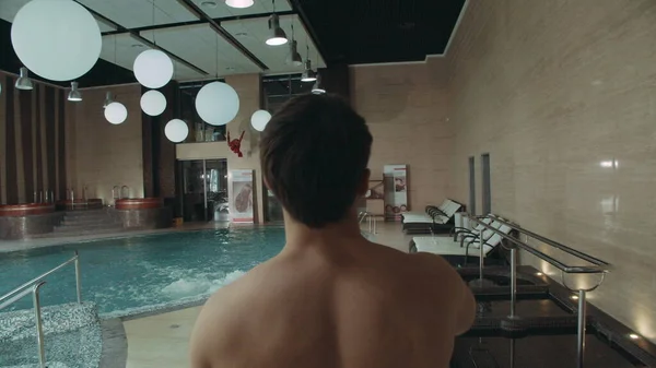 Handsome man entering hotel spa. Sporty guy looking around in spa center. — Stock Photo, Image