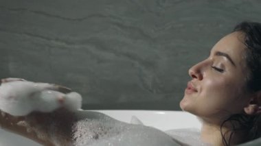 Rahat kız banyoda dinleniyor. Sıcak kadın küvette ellerini yıkıyor..