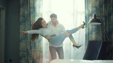 Sevimli bir çift haftasonu otelinde eğleniyor. Neşeli adam ellerde dönen kız