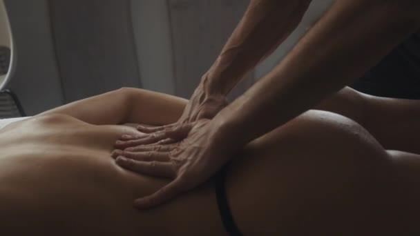 Belle femme couchée table de massage dans le spa. Masseur mains toucher fille retour. — Video