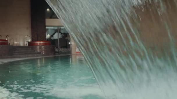 수영장에서 물이 흐릅니다. 수영 온천에서의 수압 폭포 제트. — 비디오