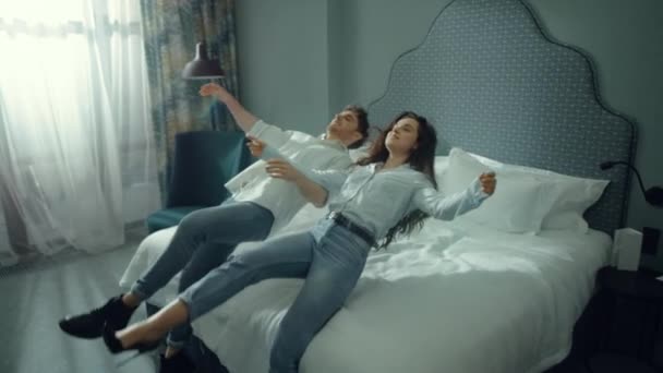 Attractive couple resting on bed. Cute man woman enjoying vacation in hotel. — Stock Video