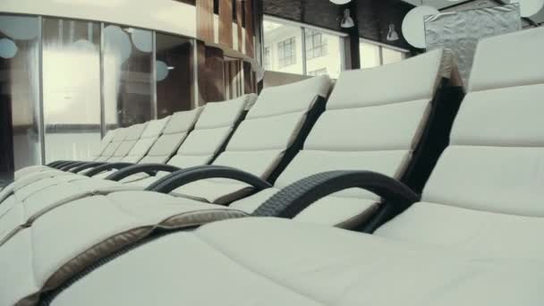Pool sängar nära poolen i simning spa. Däck stolar stående i lyx spa bakgrund. — Stockvideo