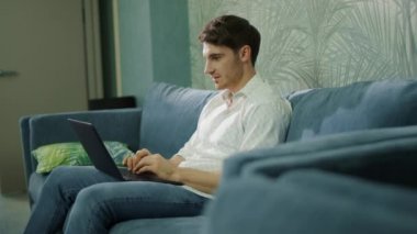 Otelde bilgisayar kullanan neşeli bir adam. Laptopta mesaj okuyan yakışıklı adam..