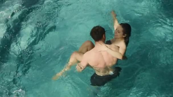 Coppia calda flirtare in piscina. Coppie sorridenti che si abbracciano nella vasca idromassaggio al chiuso. — Video Stock